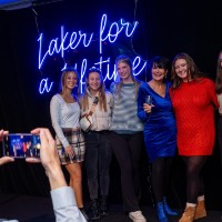 Big group of girls pose on stage with President Mantella